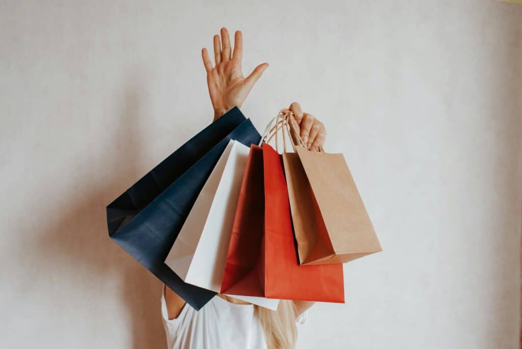 Person holding multiple shopping bags in various colors